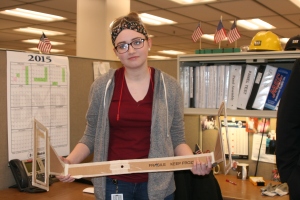 Madison holds the prototype of a manifold caliper she created on the job at Caterpillar.
